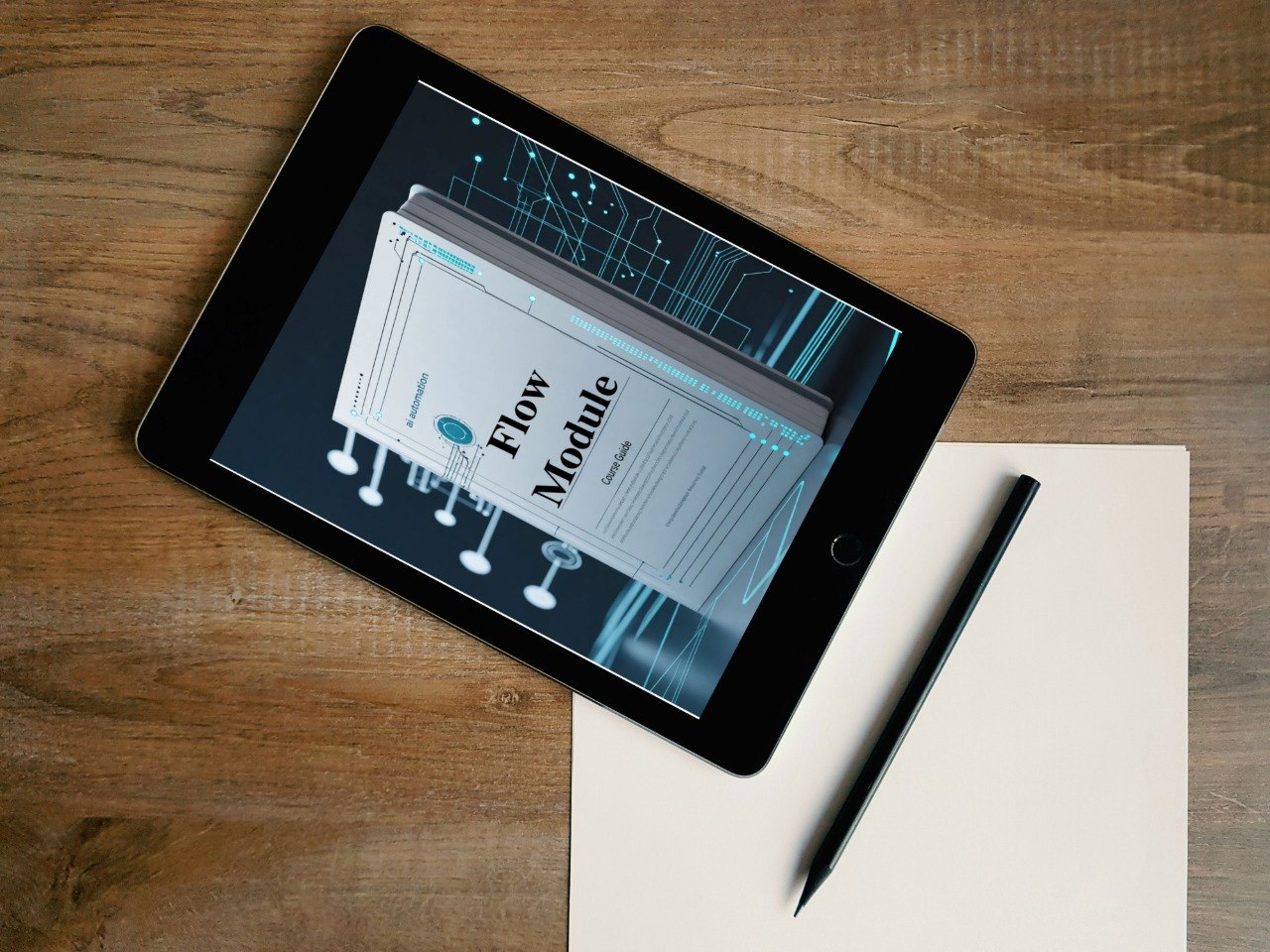 Tablet displaying a 'Flow Module' on a wooden surface with a pen and paper.